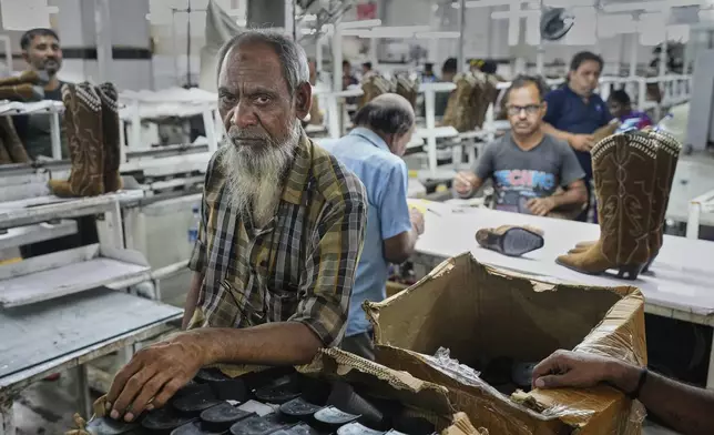 Workers at a manufacturing unit make leather footwear in Agra, India, Monday, Aug. 25, 2025. (AP Photo/Manish Swarup)