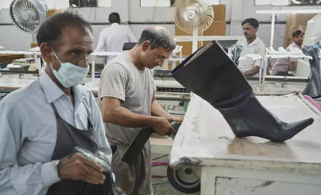 Workers in a manufacturing unit make leather footwear in Agra, India, Monday, Aug. 25, 2025. (AP Photo/Manish Swarup)