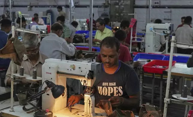 A worker stitches a footwear in a manufacturing unit in Agra, India, Monday, Aug. 25, 2025. (AP Photo/Manish Swarup)