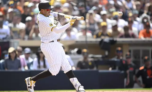 San Diego Padres' Manny Machado hits a two-RBI double during the fifth inning of a baseball game against the San Francisco Giants, Thursday, Aug. 21, 2025, in San Diego. (AP Photo/Orlando Ramirez)