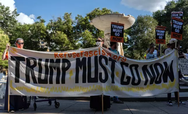 Protesters demonstrate against President Donald Trump's planned use of federal law enforcement and National Guard troops in Washington at a rally in Dupont Circle, Monday, Aug. 11, 2025, in Washington. (AP Photo/Julia Demaree Nikhinson)