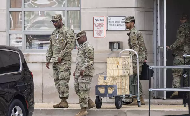 Troops load boxes of rifle ammunition at the District of Columbia National Guard Headquarters as President Donald Trump implements his order to use federal law enforcement and the National Guard to expel homeless people and rid the nation's capital of violent crime, in Washington, Tuesday, Aug. 12, 2025. (AP Photo/J. Scott Applewhite)