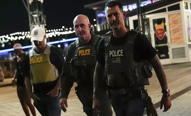 Federal law enforcement officers patrol The Wharf, Monday, Aug. 11, 2025, in Washington. (AP Photo/Julia Demaree Nikhinson)