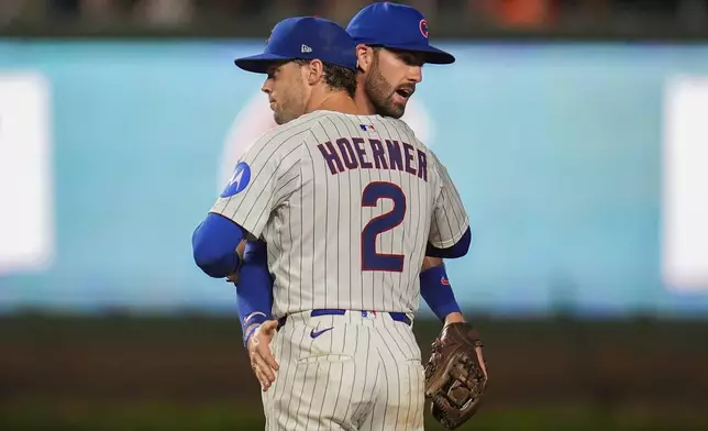 Chicago Cubs second baseman Nico Hoerner (2) and shortstop Dansby Swanson (7) celebrate their team's win over the Milwaukee Brewers in the second baseball game of a split doubleheader Tuesday, Aug. 19, 2025, in Chicago. (AP Photo/Erin Hooley)
