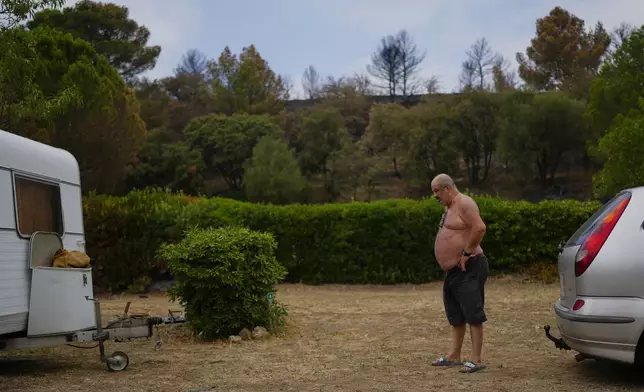 A camper prepares to leave the L'Espazo municipal campsite after France's largest wildfire in decades in Durban-Corbieres, southern France, Friday, Aug. 8, 2025. (AP Photo/Manu Fernandez)