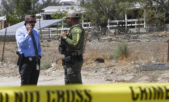 San Bernardino County Detective Eduardo Badillo, lefr, speaks on the phone alongside a Riverside County Sheriff's officer outside the home of Rebecca and Jake Haro, parents of missing 7-month-old Emmanuel Haro, on Friday, Aug. 22, 2025, in Cabazon, Calif. (Anjali Sharif-Paul/The Orange County Register via AP)
