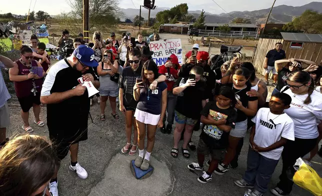 Local pastor David Hernandez, from Yucaipa, leads those gathered in prayer during a vigil for missing 7-month-old Emmanuel Haro outside the child's home in Cabazon, Calif. on Friday, Aug. 22, 2025. (Will Lester/The Orange County Register via AP)