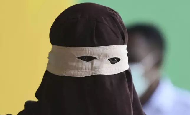 An official prepares to cane people who violate Shariah law including two men accused of hugging and kissing, acts the court ruled can lead to banned sexual relations, in Banda Aceh, Aceh province, Indonesia, Tuesday, Aug. 26, 2025. (AP Photo/ Reza Saifullah)