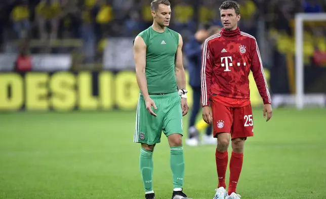 FILE - Bayern goalkeeper Manuel Neuer, left, and Bayern's Thomas Muller react after the German Supercup final soccer match between Borussia Dortmund and Bayern Munich in Dortmund, Germany, Saturday, Aug. 3, 2019. (AP Photo/Martin Meissner, file)