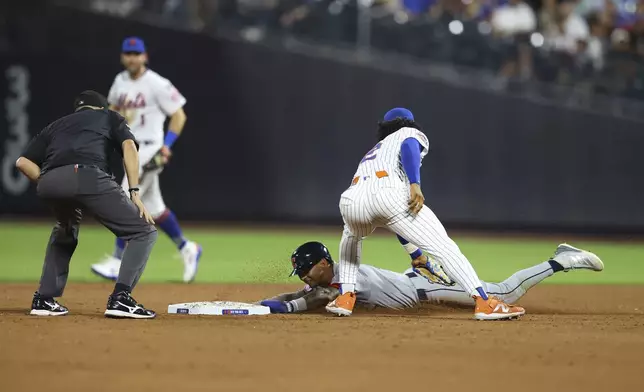 Cleveland Guardians' Brayan Rocchio, bottom right, steals second base during the ninth inning of a baseball game against the New York Mets at Citi Field in New York, Monday, Aug. 4, 2025. (Gordon Donovan via AP)