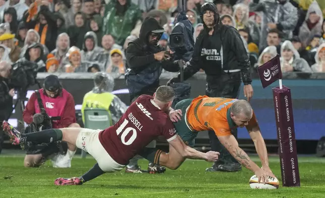 Australia's Dylan Pietsch goes over to score the opening try despite the challenge of Finn Russell of the British &amp; Irish Lions during the third and final rugby union test between the Lions and the Wallabies in Sydney, Australia, Saturday, Aug. 2, 2025. (AP Photo/Mark Baker)