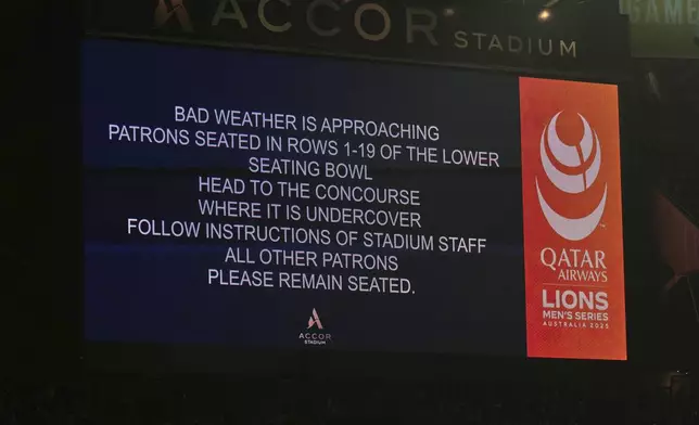 A sign warns of bad weather approaching which caused a suspension of play during the third and final rugby union test between the Lions and the Wallabies in Sydney, Australia, Saturday, Aug. 2, 2025. (AP Photo/Mark Baker)