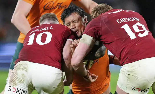 Australia's Len Ikitau is tackled by Finn Russell and Ollie Chessum of the British &amp; Irish Lions during the third and final rugby union test between the Lions and the Wallabies in Sydney, Australia, Saturday, Aug. 2, 2025. (AP Photo/Rick Rycroft)