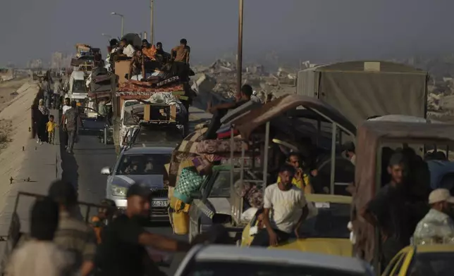 Displaced Palestinians fleeing northern Gaza Strip move with their belongings along the Sea Road, near Wadi Gaza, Saturday, Aug. 30, 2025. (AP Photo/Abdel Kareem Hana)