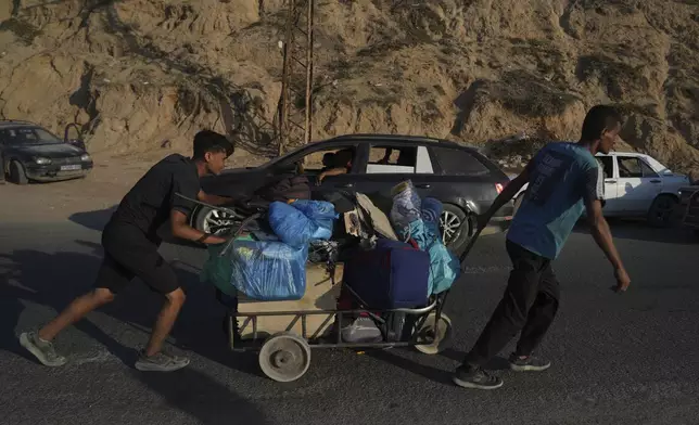 Displaced Palestinians fleeing northern Gaza Strip move with their belongings along the Sea Road, near Wadi Gaza, Saturday, Aug. 30, 2025. (AP Photo/Abdel Kareem Hana)