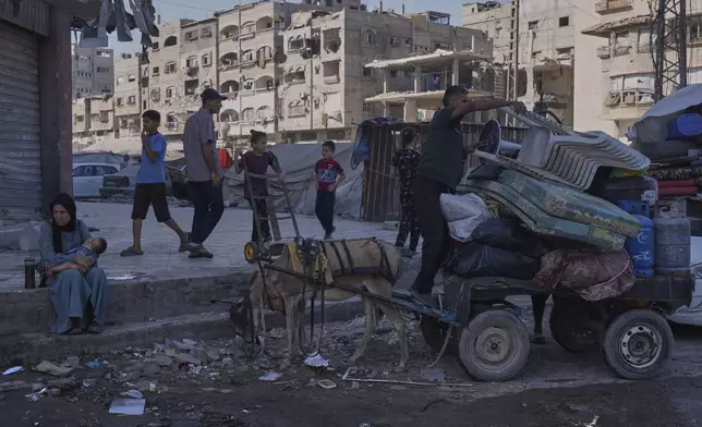 Displaced Palestinians fleeing northern Gaza Strip move with their belongings on a street in Gaza City, Thursday, Aug. 28, 2025. (AP Photo/Abdel Kareem Hana)