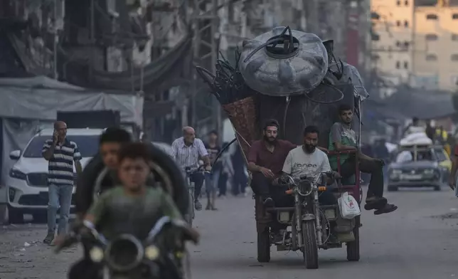 Displaced Palestinians fleeing northern Gaza Strip move with their belongings on a street in Gaza City, Friday, Aug. 29, 2025. (AP Photo/Jehad Alshrafi)