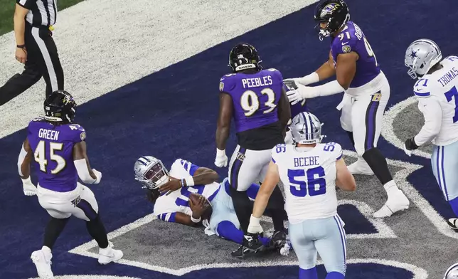 Dallas Cowboys quarterback Joe Milton III is sacked for a safety as Baltimore Ravens' Mike Green, Aeneas Peebles and C.J. Ravenell (91) look on in the first half of a preseason NFL football game Saturday, Aug. 16, 2025, in Arlington, Texas. (AP Photo/Gareth Patterson)