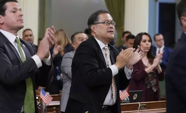 California Assembly member Mike Fong, D-Alhambra, center, celebrates with other lawmakers after the Assembly approved the first of three measures to redraw the state's Congressional districts and put new maps before voters in a special election, during a news conference in Sacramento, Calif., Thursday, Aug. 21, 2025. (AP Photo/Rich Pedroncelli)
