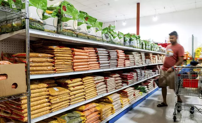 A customer shops a grain aisle at New India Bazar, where most merchandise is imported from India and Canada, on Wednesday, Aug. 6, 2025, in Fremont, Calif. (AP Photo/Noah Berger)
