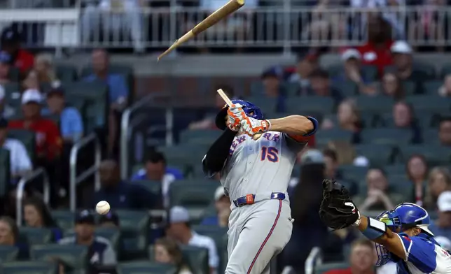 New York Mets' Tyrone Taylor breaks his bat as he hits during the third inning of a baseball game against the Atlanta Braves, Saturday, Aug. 23, 2025, in Atlanta. (AP Photo/Butch Dill)