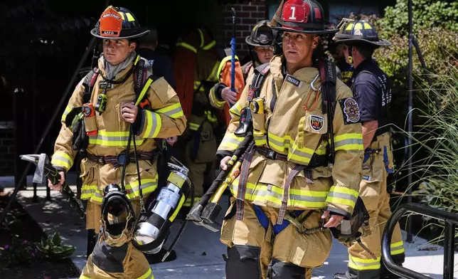 Firefighters respond to a fire while wearing recently issued non-PFAS turnout gear on July 3, 2025, in East Providence, R.I. (AP Photo/Charles Krupa)