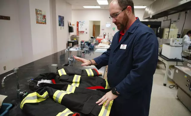 Bryan Ormond, a professor at the Textile Protection and Comfort Center at North Carolina State University, talks about the protective layers in a firefighter jacket on Aug. 8, 2025, in Raleigh, N.C. (AP Photo/Allen G. Breed)