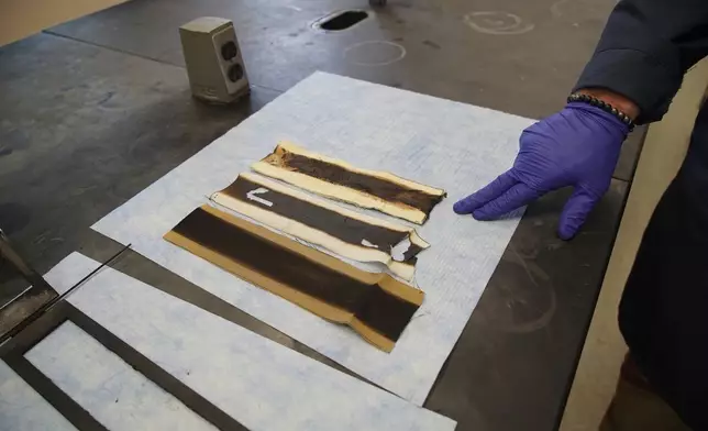 Charred pieces of non-PFAS-treated fabric sit on a lab bench following a burn test at North Carolina State University's Wilson College of Textiles in Raleigh, N.C., Aug. 8, 2025. (AP Photo/Allen G. Breed)