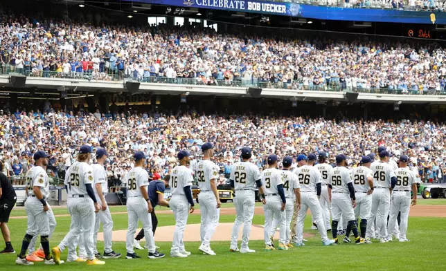 Milwaukee Brewers players walk onto the field for the ceremonial first pitch during the Bob Uecker Celebration of Life before a baseball game against the San Francisco Giants, Sunday, Aug. 24, 2025, in Milwaukee. (AP Photo/Jeffrey Phelps)