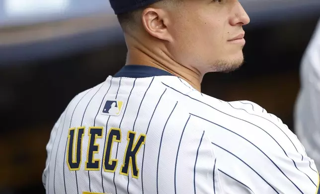 Milwaukee Brewers' Isaac Collins watches from the dugout during the Bob Uecker Celebration of Life ceremony before a baseball game between the San Francisco Giants and the Milwaukee Brewers, Sunday, Aug. 24, 2025, in Milwaukee. (AP Photo/Jeffrey Phelps)