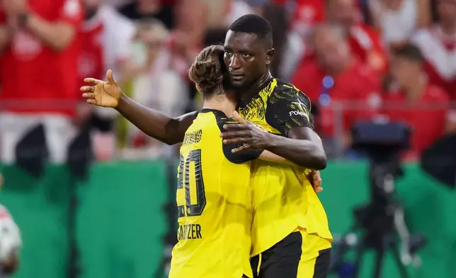 Borussia Dortmund's Serhou Guirassy, right, celebrates scoring a goal with teammate Marcel Sabitzer, during the German Cup first-round soccer match between Essen and Borussia Dortmund, at Stadion an der Hafenstrasse in Essen, Germany, Monday, Aug. 18, 2025. (Christoph Reichwein/dpa via AP)