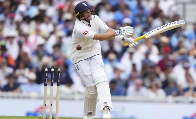 England's Joe Root reacts after a ball hit him on day four of the fifth cricket test match between England and India at The Kia Oval in London, Sunday, Aug. 3, 2025. (AP Photo/Kirsty Wigglesworth)