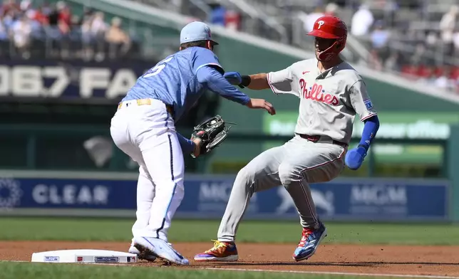 Philadelphia Phillies' Trea Turner, right, is caught attempting to steal third base by Washington Nationals third baseman Brady House, left, during the first inning of a baseball game, Saturday, Aug. 16, 2025, in Washington. (AP Photo/Nick Wass)