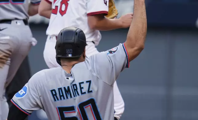 Miami Marlins' Agustin Ramirez (50) scores behind Cleveland Guardians starting pitcher Tanner Bibee (28) in the first inning of a baseball game in Cleveland, Thursday, Aug. 14, 2025. (AP Photo/Sue Ogrocki)