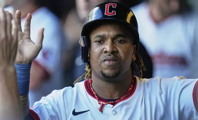 Cleveland Guardians' Jose Ramirez is congratulated in the dugout after scoring in the first inning of a baseball game against the Miami Marlins in Cleveland, Thursday, Aug. 14, 2025. (AP Photo/Sue Ogrocki)