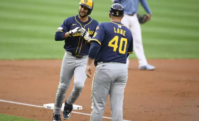 Milwaukee Brewers Blake Perkins, left, celebrates after his home run with third base coach Jason Lane (40) during the second inning of a baseball game against the Washington Nationals, Friday, Aug. 1, 2025, in Washington. (AP Photo/Nick Wass)