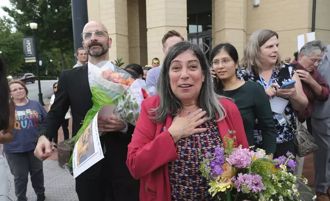 Dr. Demetre Daskalakis, left, and Dr. Debra Houry is greeted by friends as workers and supporters rally for departing scientific leaders at the Centers for Disease Control and Prevention outside the CDC headquarters, Thursday, Aug. 28, 2025, in Atlanta. (AP Photo/Ben Gray)