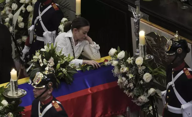 Claudia Tarazona leans on the coffin of her husband, presidential hopeful and opposition Sen. Miguel Uribe, who died from wounds suffered when he was shot at a political rally, at Congress in Bogota, Colombia, Tuesday, Aug. 12, 2025. (AP Photo/Ivan Valencia)