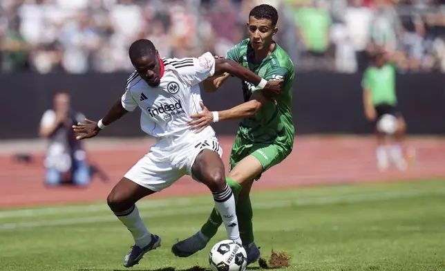 Frankfurt's Niels Nkounkou, left, and Enger's Ed-Daoudi Ayman, right, challenge for the ball during the German soccer cup first round match between FV Engers and Eintracht Frankfurt in Koblenz, Germany, Sunday Aug. 17, 2025. (Thomas Frey/dpa via AP)