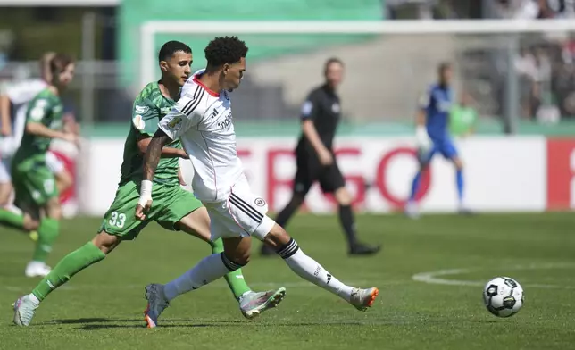 Frankfurt's Nnamdi Collins, front right, and Enger's Ed-Daoudi Ayman, front left, challenge for the ball during the German soccer cup first round match between FV Engers and Eintracht Frankfurt in Koblenz, Germany, Sunday Aug. 17, 2025. (Thomas Frey/dpa via AP)