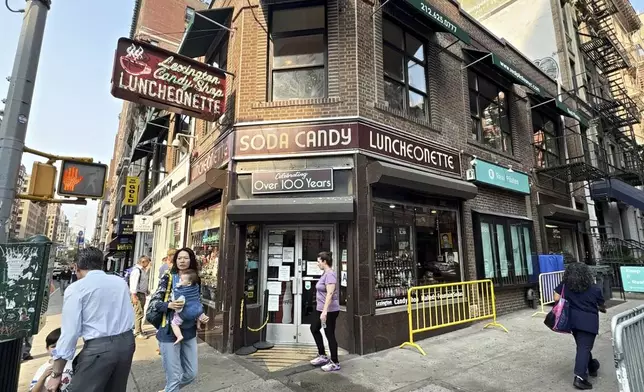 Pedestrians walk outside the Lexington Avenue Candy Shop Luncheonette in New York on Aug. 7, 2025. (AP Photo/Guido Neira)