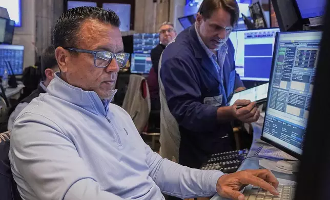 Traders Robert Finnerty Jr., left, and Michael Milano work on the floor of the New York Stock Exchange, Tuesday, July 29, 2025. (AP Photo/Richard Drew)