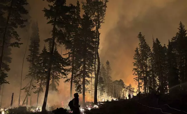 In this photo provided by the Hurricane Valley Fire District, firefighters work to subdue the Monroe Canyon Fire near Monroe, Utah, Thursday, July 24, 2025. (Hurricane Valley Fire District via AP)