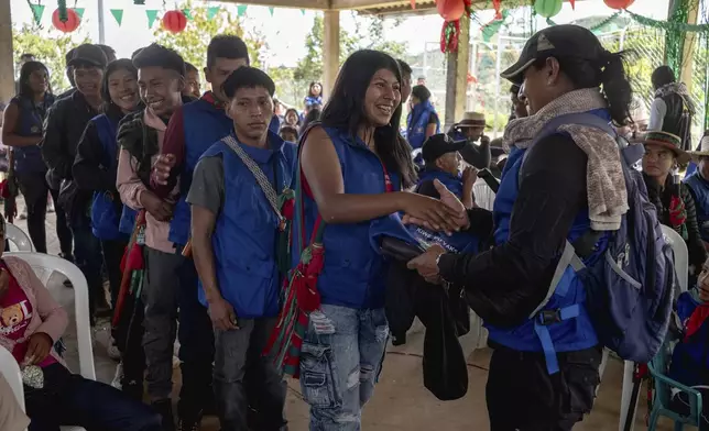 Teenagers and young adults receive an Indigenous guard vest and a folding chair at the end of the graduation ceremony on July 18, 2025, in Manuelico village, Caldono, Colombia. (AP Photo/Nadège Mazars)