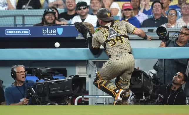 San Diego Padres catcher Freddy Fermin is unable the catch a foul ball hit by Los Angeles Dodgers' Andy Pages during the second inning of a baseball game Friday, Aug. 15, 2025, in Los Angeles. (AP Photo/Mark J. Terrill)