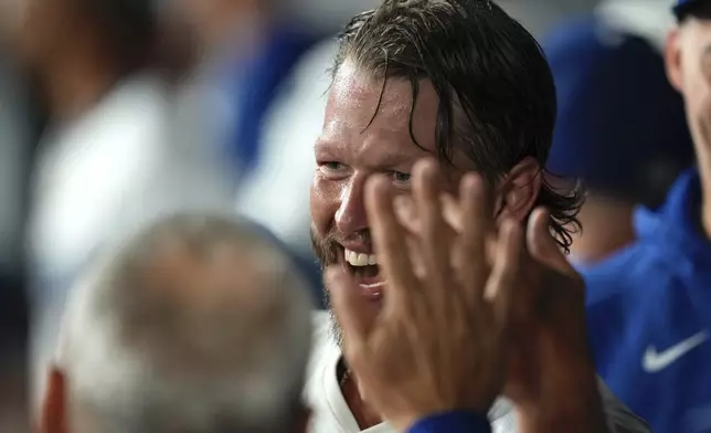 Los Angeles Dodgers starting pitcher Clayton Kershaw is congratulated by teammates in the dugout after finishing the sixth inning of a baseball game against the San Diego Padres, Friday, Aug. 15, 2025, in Los Angeles. (AP Photo/Mark J. Terrill)