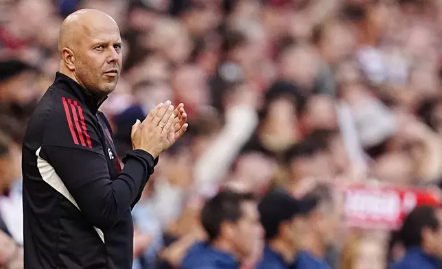 Liverpool manager Arne Slot claps as the crowd play tribute to Diogo Jota in the 20th minute during the pre-season friendly soccer match between Liverpool and Athletic Bilbao, at Anfield, Liverpool, England, Monday Aug. 4, 2025. (Peter Byrne/PA via AP)