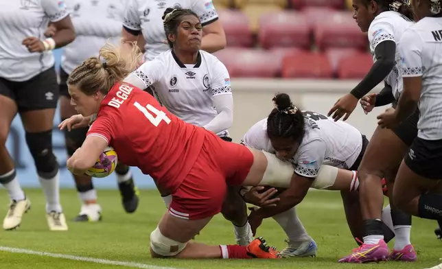 Canada's Sophie de Goede, left, scores a try during the Women's Rugby World Cup 2025 Pool B match between Canada and Fiji at the York Community Stadium in York, England, Saturday, Aug. 23, 2025. (Danny Lawson/PA via AP)
