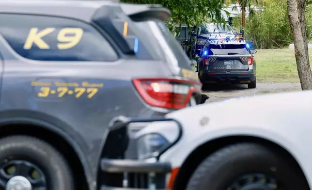 Law enforcement vehicles are parked at the scene where Michael Paul Brown, a suspect in a shooting at a Montana bar that left four people dead, was apprehended on Friday, Aug. 8, 2025, outside of Anaconda, Mont. (Joseph Scheller/The Montana Standard via AP)