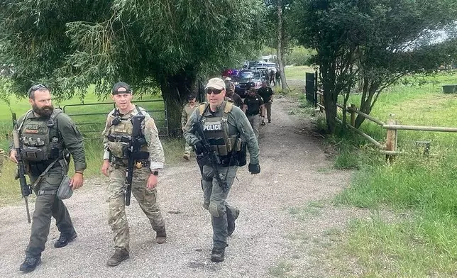 Law enforcement officers are seen at the scene where Michael Brown, a suspect in a shooting at a Montana bar that left four people dead, was apprehended on Friday, Aug. 8, 2025, outside of Anaconda, Mont. (Duncan Adams/The Montana Standard via AP)